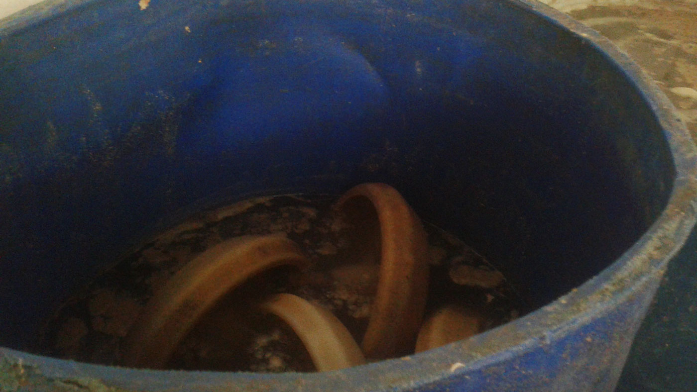 Lavare le mangiatoie in un fusto